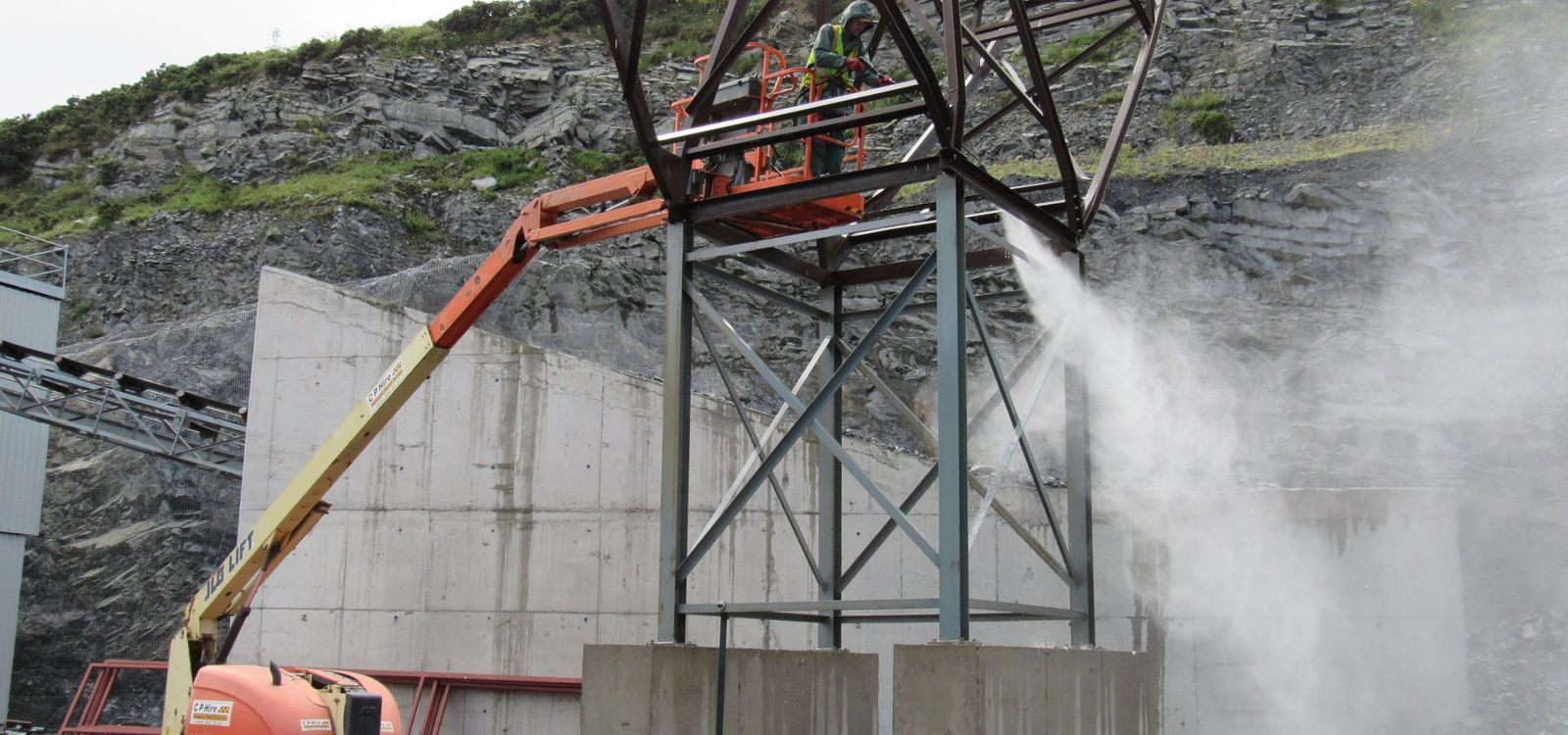 FG Fegan operative blast cleaning steelwork at a quarry from an access platform